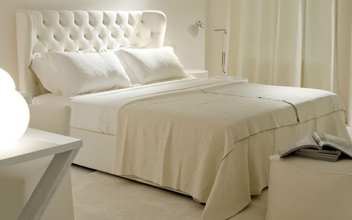 белая кровать с мягкой спинкой